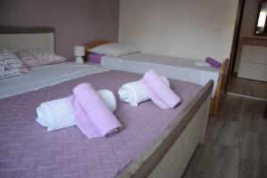 a bedroom with two beds with purple and white towels at Apartment Bepo in Pakoštane