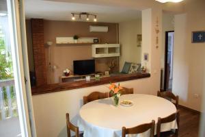 une salle à manger avec une table et un salon dans l'établissement Apartment Bepo, à Pakoštane