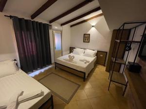 Kleines Zimmer mit 2 Betten und einer Leiter in der Unterkunft Hotel Kappa3 Villas in Vlorë