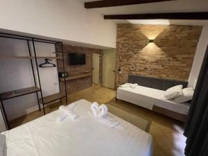 a bedroom with two beds and a brick wall at Hotel Kappa3 Villas in Vlorë