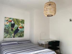 a bedroom with a bed with a painting on the wall at Piso en la Playa in Ribeira