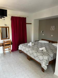 a bedroom with a large bed and a red curtain at Islands Apartments in Petra