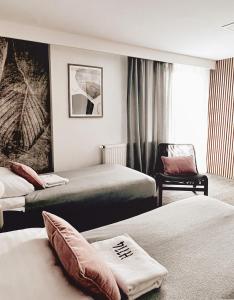 una habitación de hotel con 2 camas y una silla en Wygodne Pokoje H114, en Gliwice