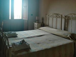 a bedroom with a large bed with a window and a window at Il Borgo & il Feudo in Badolato