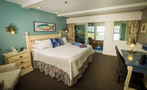 um quarto com uma cama com paredes azuis e uma janela em Island View Inn em Glen Cove