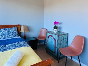 Un dormitorio con una cama y dos sillas y una mesa. en Queen Room in share house of De Murray B&B in Centre Queanbeyan & Canberra airport, en Queanbeyan