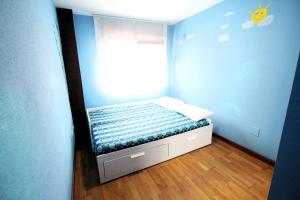 uma pequena cama num quarto azul com uma janela em CONOCE CANGAS DE ONIS em Cangas de Onís