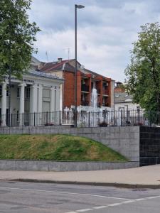 budynek z fontanną przed nim w obiekcie VYTAUTO 3 apartment w mieście Wiłkomierz