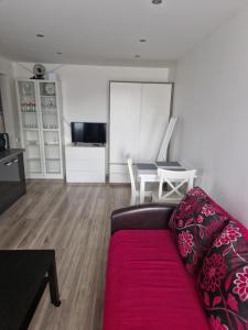uma sala de estar com um sofá vermelho e uma mesa em VYTAUTO 3 apartment em Ukmergė