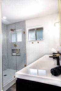 a bathroom with a shower and a white tub at Mojave Desert Pied-à-terre in Yucca Valley