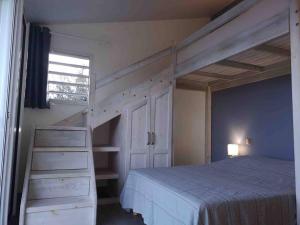 um quarto com um beliche e uma escada ao lado de uma cama em Villa Madjic em Sainte-Luce
