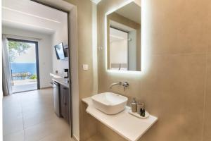 W łazience znajduje się umywalka i lustro. w obiekcie Lithitsa Lofts and Suites w mieście Parga