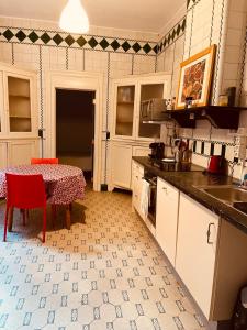eine Küche mit einem Tisch und einem roten Stuhl darin in der Unterkunft Magnifique appartement au rdc dans une maison de maître avec cour extérieure in Lüttich