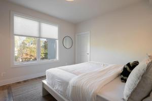 a white bedroom with a bed and a window at Piedmont Place Suite 304 - near vineyards! in Crozet