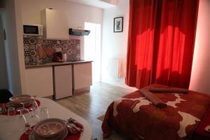 1 dormitorio con cortina roja, mesa y cama en Saturne, en Saint-Quentin