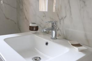un lavandino bianco del bagno con una tazza di caffè di Il Borgo civ.15 a Paola Altre 34 foto
