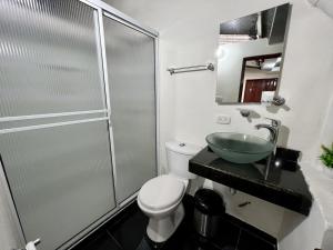een badkamer met een douche, een toilet en een wastafel bij Tucan Hostal in Circasia