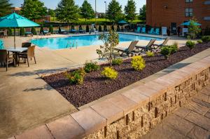 a swimming pool with chairs and tables and an umbrella at Patriots Inn in Williamsburg