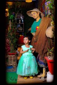 Una niña con un vestido azul parada junto a una mujer en GREEN LEAF GUEST HOUSE en Sreemangal