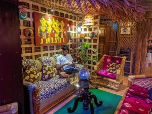 GREEN LEAF GUEST HOUSE في سريمانغال: رجل يجلس على أريكة في غرفة