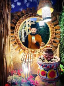 un homme prenant une photo de lui-même dans un miroir dans l'établissement GREEN LEAF GUEST HOUSE, à Sreemangal