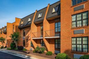 a red brick building with windows and bushes at Patriots Inn in Williamsburg