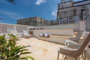 eine Dachterrasse mit Stühlen und einem Gebäude in der Unterkunft Casa Luxor Cartagena by Soho in Cartagena de Indias