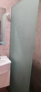 ein Badezimmer mit einem weißen Waschbecken und einer Dusche in der Unterkunft Mono ambiente Loria in Ciudad Lujan de Cuyo + 5 Fotos