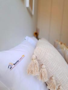 a white bed with tassels on top of it at Boavista Luxury Villas in Porto