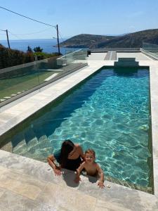 una mujer y un niño en una piscina en Greek Sea Villas Kaki Thalassa 400 meters to the beach en Keratea