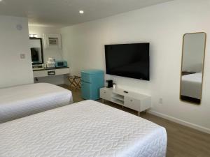 Habitación de hotel con 2 camas y TV de pantalla plana. en Poolside Double Rooms en Lake City