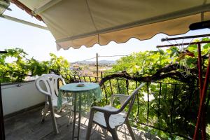 a balcony with a table and two chairs and an umbrella at Villa Sofia Nea Peramos in Néa Péramos