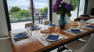 a dining room table with a vase of purple flowers at Villa Ker Bunk in Audierne