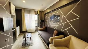 a living room with a couch and a tv at Heaven Meydan Apartments in Trabzon