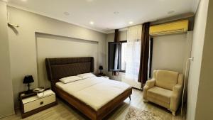 a bedroom with a bed and a chair at Heaven Meydan Apartments in Trabzon
