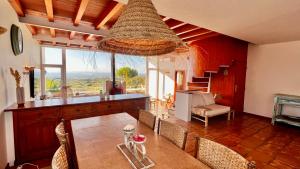 un comedor con mesa y sillas y una escalera en Lovely Beach House with Stunning View, en Sesimbra