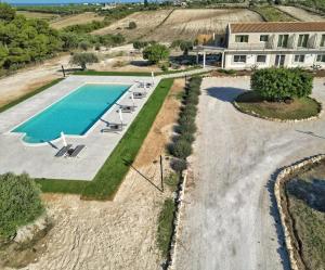 una vista sul soffitto di una piscina con sedie e di un edificio di Carrua a Marzamemi