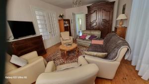 a living room with couches and a flat screen tv at Logis de Pagnolet in Ozillac