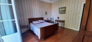 a bedroom with a bed and a table with a chair at Logis de Pagnolet in Ozillac