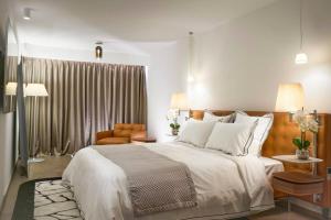 1 dormitorio con 1 cama blanca grande y 1 silla en Luxurious 3BR6p apartment with terrace - First Croisette Cannes 602 en Cannes