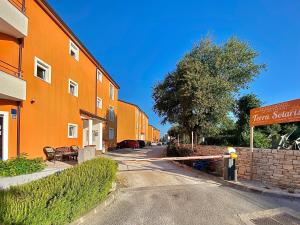 an empty street with an orange building and a fire hydrant at Apartments Terra Solaris in Medulin