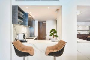 cocina con encimera blanca y 2 sillas en Luxurious 3BR6p apartment with terrace - First Croisette Cannes 602 en Cannes