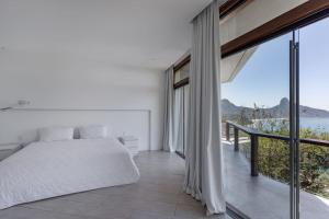 um quarto com uma cama e uma grande janela em Mansão fascinante com vista para o mar e montanhas - Joá - Rio de Janeiro no Rio de Janeiro