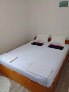 a bed with white sheets and two books on it at Apartment Italiano in Split