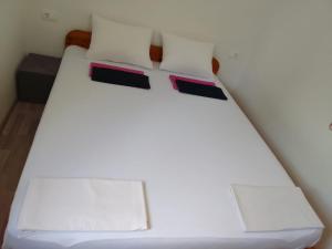 a bed with white sheets and two pillows at Apartment Italiano in Split