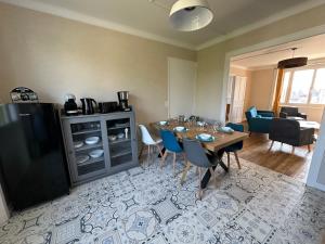 a living room with a table and a dining room at Chez Tante Muguette proche Dinan in Le Hinglé +9 photos