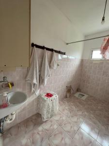 a pink tiled bathroom with a sink and a mirror at a peaceful holiday in a village environment in İyidere