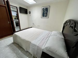 a bedroom with a large white bed in a room at Tucan Hostal in Circasia