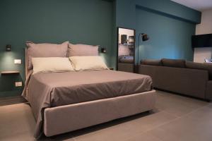 a bedroom with a large bed and a couch at Oktò apartments Milazzo in Milazzo