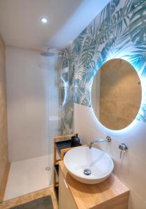 ein Bad mit einem Waschbecken und einem Spiegel in der Unterkunft Gunlayer Maisonette in Floriana